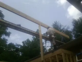 Carpenter setting a ridge beam over a new addition frame — Ice Dam Removal by Roofing Brothers in Edgewater